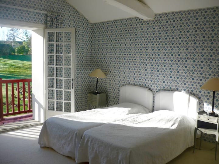 חדר שינה כחול בקומה העליונה עם מרפסת וחדר רחצה צמוד.