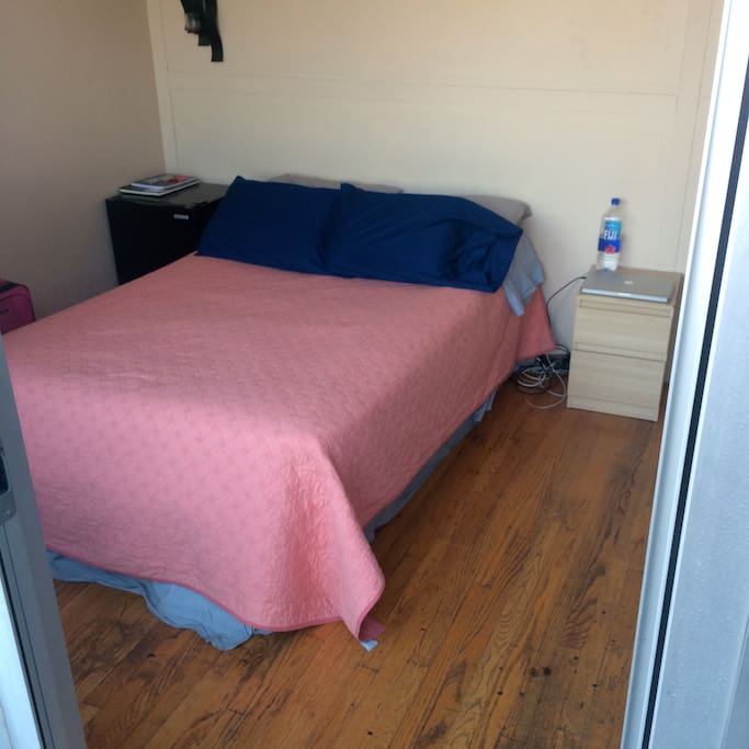 Queen size bed and side table. hardwood floors.