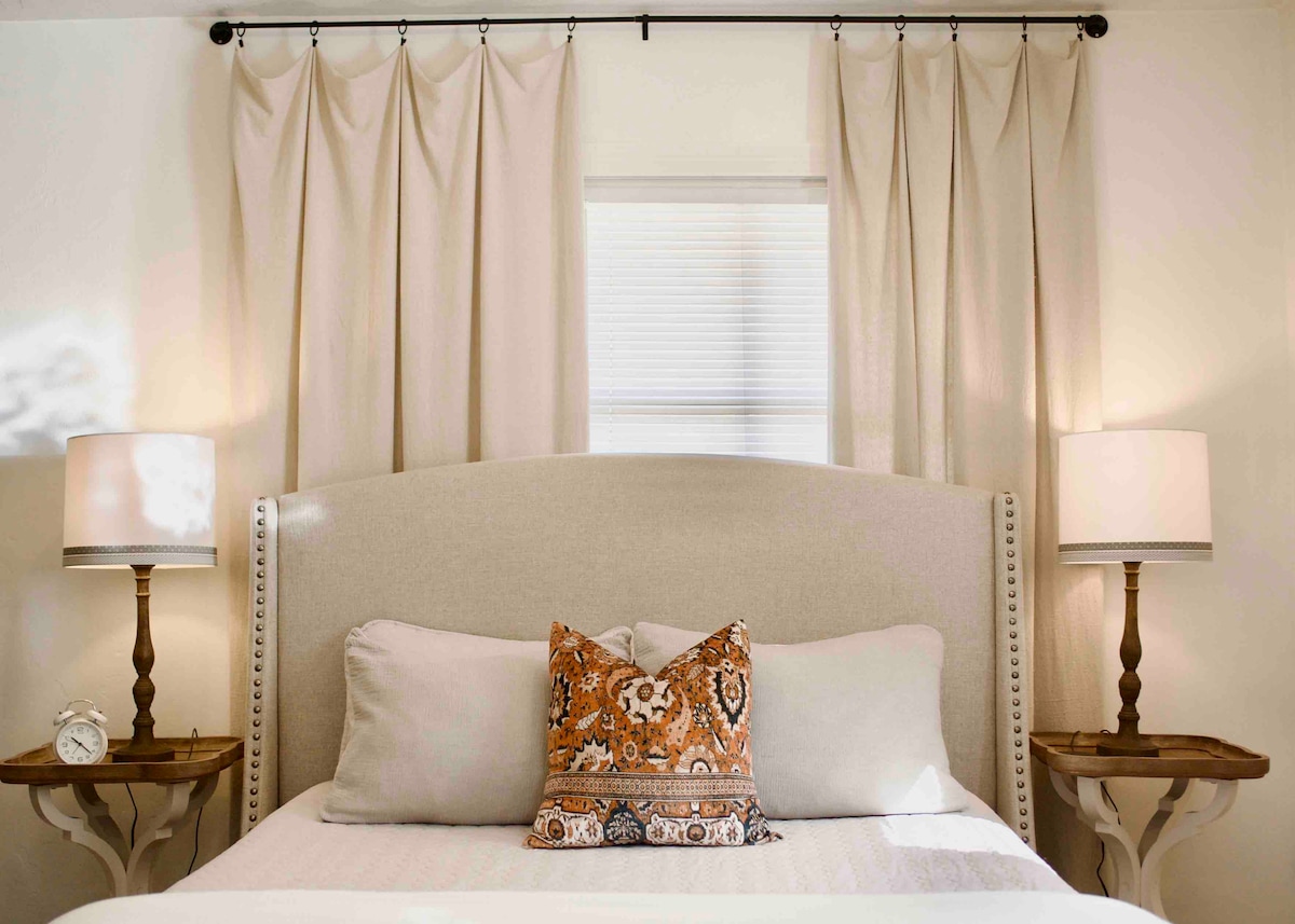 Queen size bed tastefully appointed with luxury bed linens.