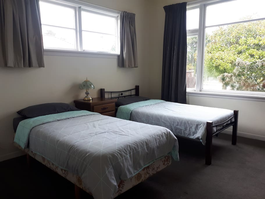 Bedroom 1. Two single beds, draws, mirror and a bedside lamp.