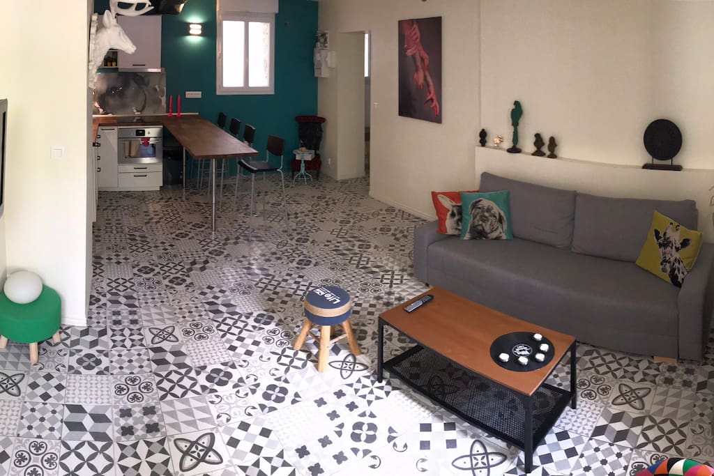 Un grand salon de 30 m² avec cuisine ouverte. Les équipements sont neufs. Il s’agit d’un canapé lit.