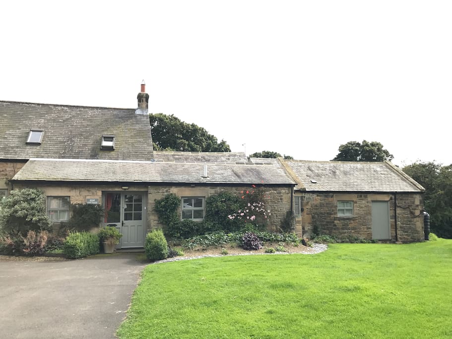 Rose Cottage with the Barn to the right, showing the parking area.