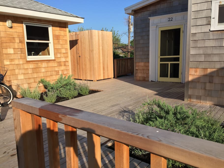 Front door at right, shed with washer/dryer, beach chairs, etc. to left, outdoor shower in middle.