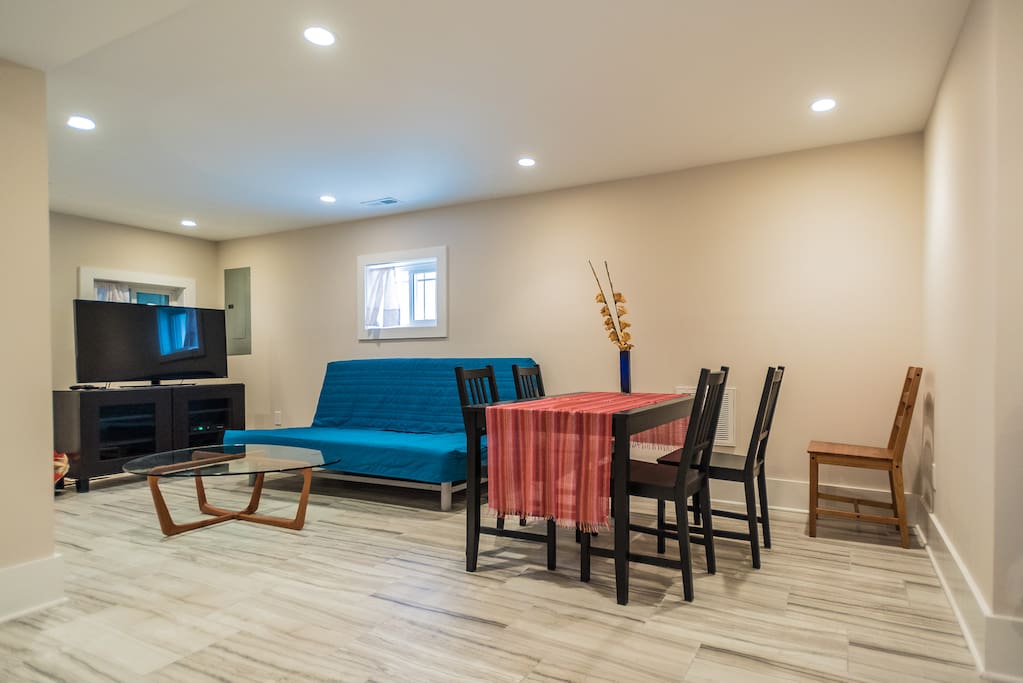 Spacious open living room with dining area, TV, and kitchenette