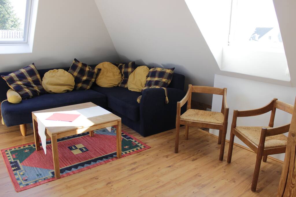 Hier das Sofa und ein ganz bisschen ist die Aussicht über Friedberg zu erahnen. Der Raum ist hell, die Fenster haben dichte Rollos für die Nacht.