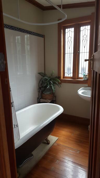 Shared bathroom with shower over claw foot bath.