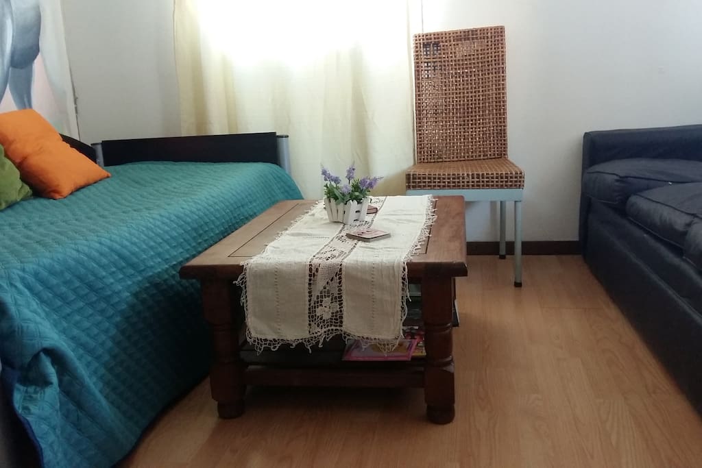 Living comedor con cama marinera y in sofá, mesa ratona con revistas y almohadones