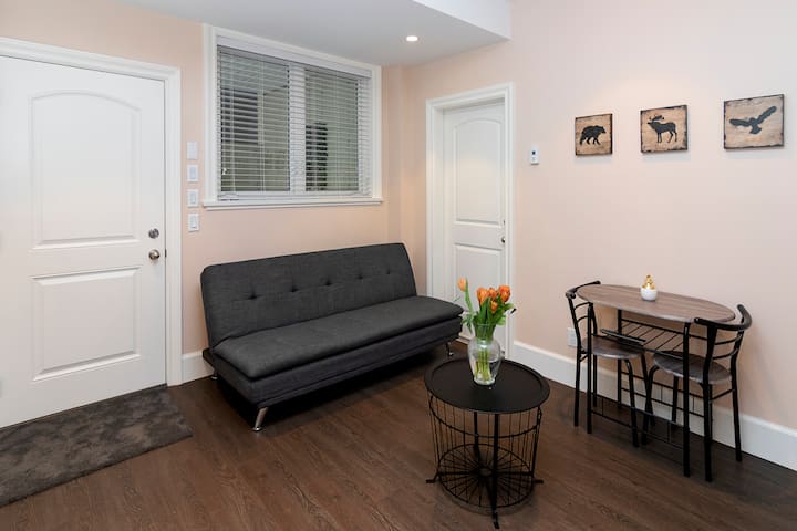 Sala de estar con sofá cama futón, juego de mesa de comedor de 2