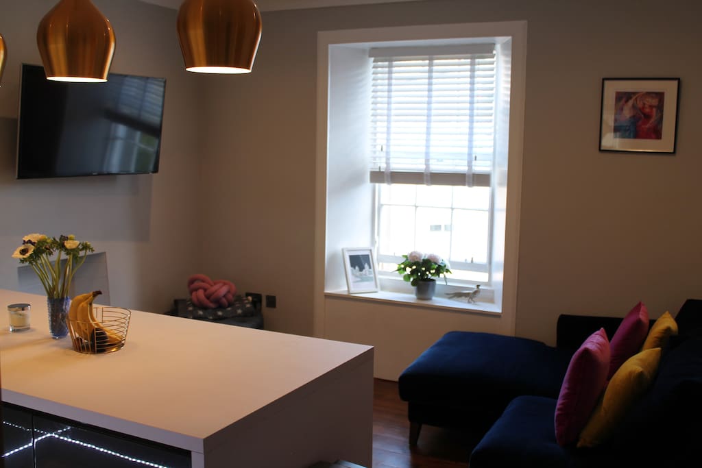 Comfortable lounge area with a good view of the large Smart TV.