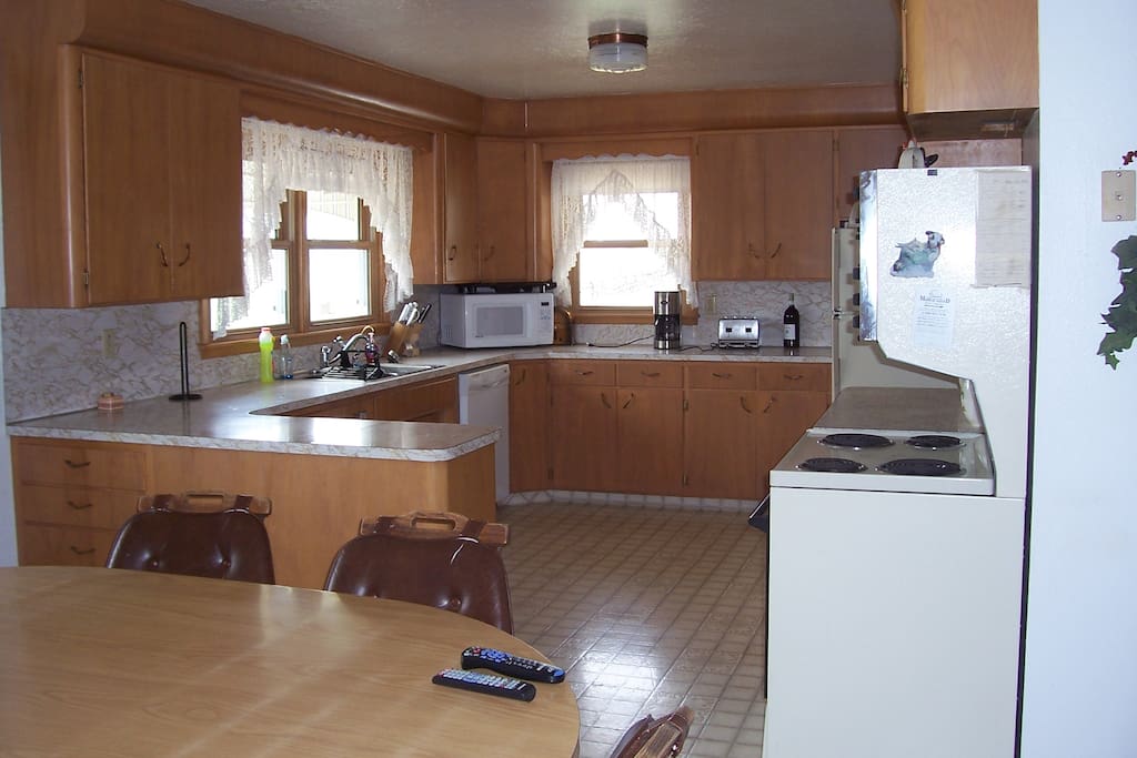 Large country kitchen is fully furnished with dishes and cook ware.