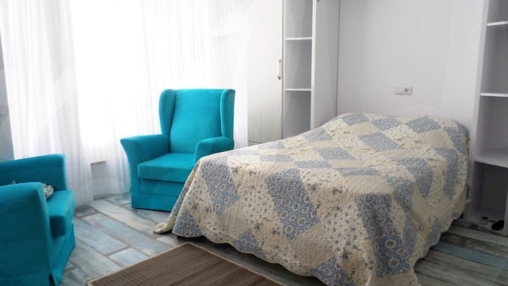 A comfortable double bed. There is one turquoise chair at the moment to create more space. 