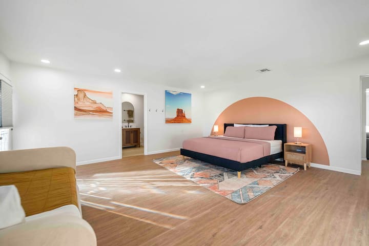 - ელეგანტური უდაბნო შთაგონებული აპარტამენტი ხელოვნების ნიმუშებითა და თბილი ტონებით   - საწოლი, ფერადი ხალიჩა და თვალისმომჭრელი ლამპები მყუდრო კომფორტს ქმნის - პირდაპირ სააბაზანოში შესვლა ხელს უწყობს თქვენს Airbnb სტუმრობას  