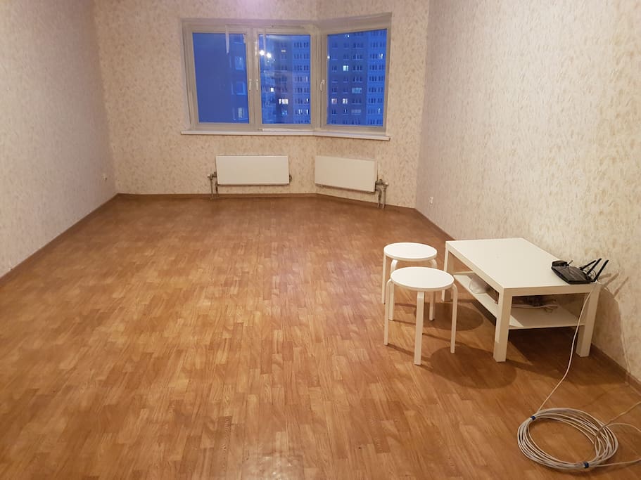 Lounge. There are window curtains, 2 sofa beds and a modern TV set