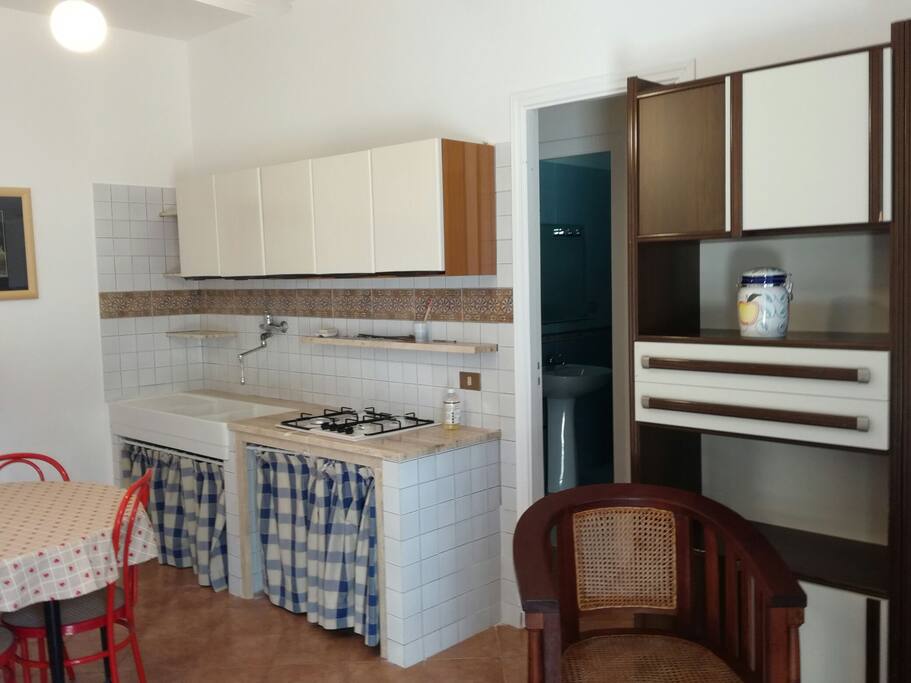 cucina soggiorno con televisore ,la porta d'ingresso da su un ampio terrazzo coperto ,circondato da giardino con possibilità di posteggio