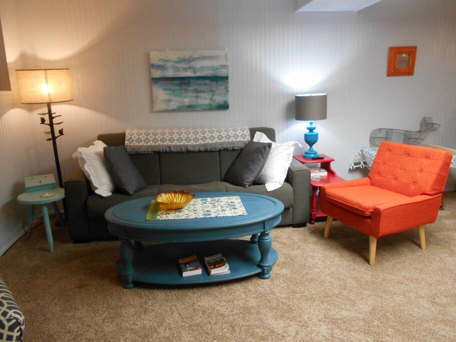 Large and cozy living room with cable and Roku TV. Couch is a full sized futon bed. Twin sized roll away fits nicely in this space.