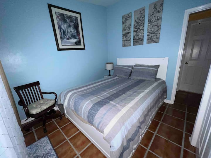 Chumba cha nne cha kulala,  chenye kitanda aina ya queen na mlango wa kifaransa unaoelekea kwenye eneo la bwawa