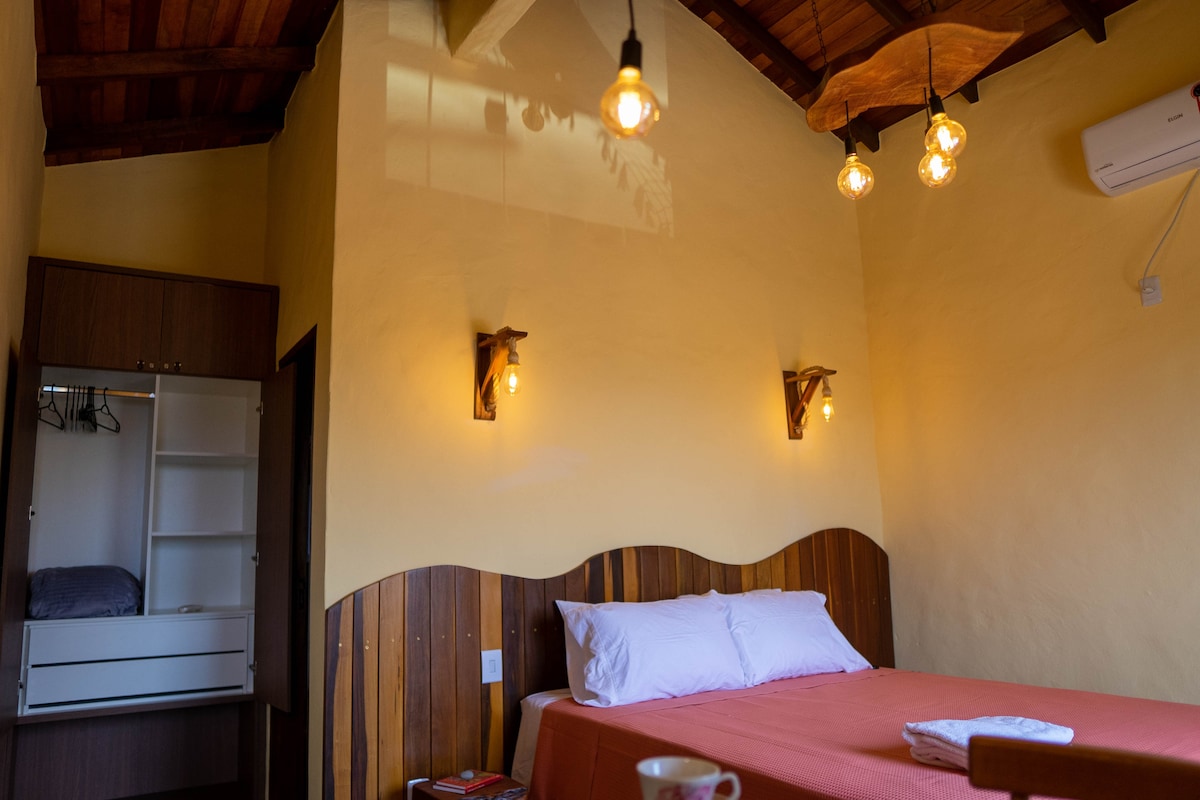 Kitanda cha ukubwa wa malkia kilicho na matandiko mazuri na kabati kubwa.