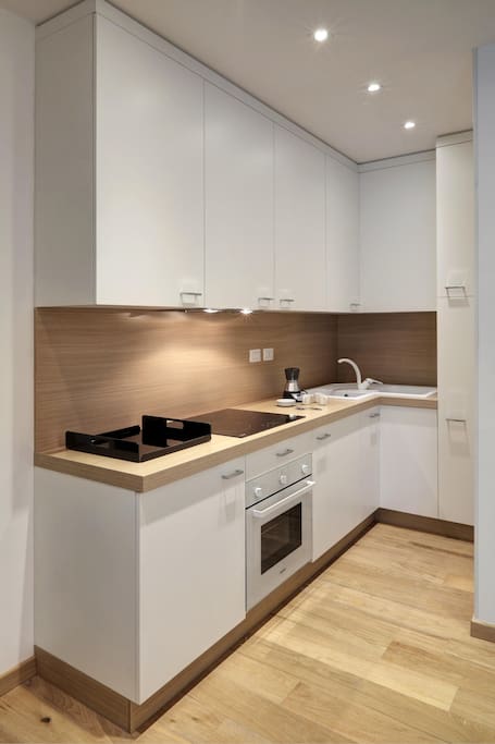 cucina attrezzata con frigo, forno, stoviglie, macchina da caffè e lavasciuga