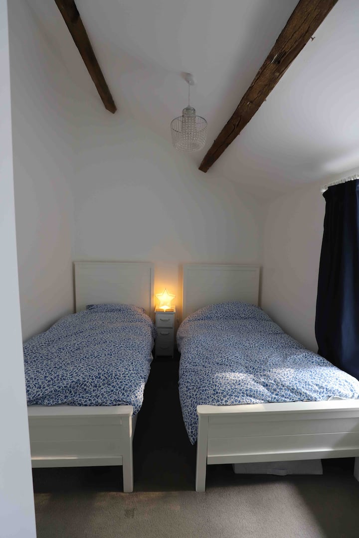 Dvojlôžková spálňa so šatníkom a oknom pred chalupou.