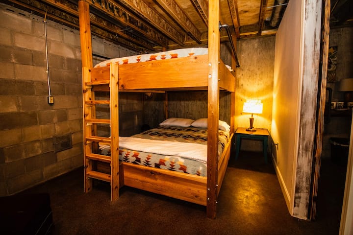 Spálňa v suteréne s poschodovými posteľami veľkosti Queen