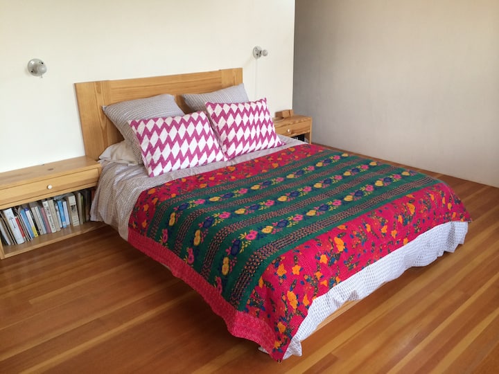 Un dormitorio principal iluminado por el sol con vistas al jardín.
Un vestidor con amplio espacio para colgar ropa y cajones para guardarla.