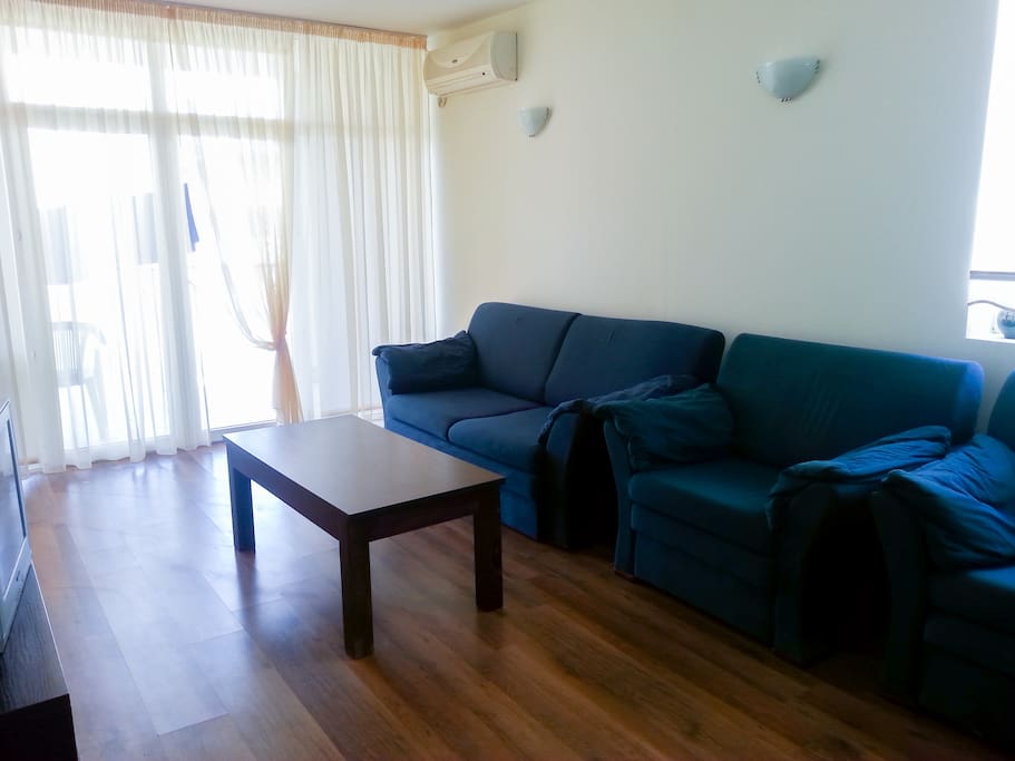 Living room: a view outside the terrace window. Living room has a double sofa bad and two armchairs.