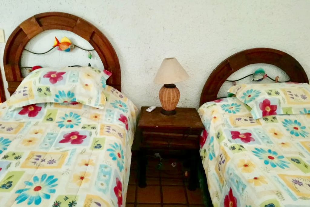 Habitacion con 2 camas individuales y aire acondicionado.