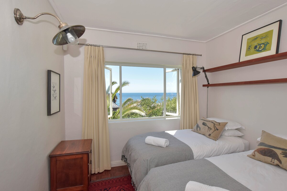ห้องนอนที่สองที่มีเตียงแฝดและวิวทะเล เตียงเหล่านี้สามารถเปลี่ยนเป็นเตียงขนาดคิงไซส์เดี่ยวได้ตามคำขอ