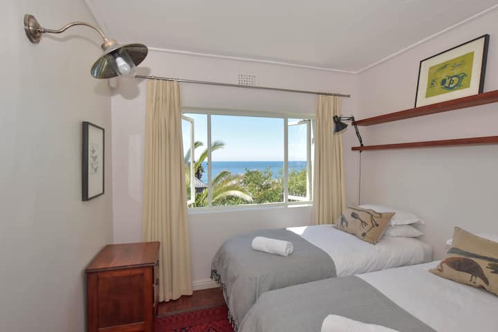 El segundo dormitorio con sus camas individuales y vistas al mar. Estas camas se pueden convertir en una cama individual tamaño king bajo petición.