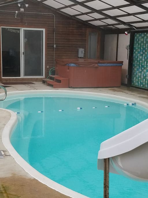 enclosed Swimming pool with hot tub.