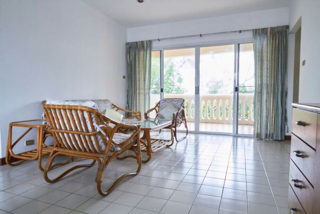 Lounge area with balcony over looking lush green area.
