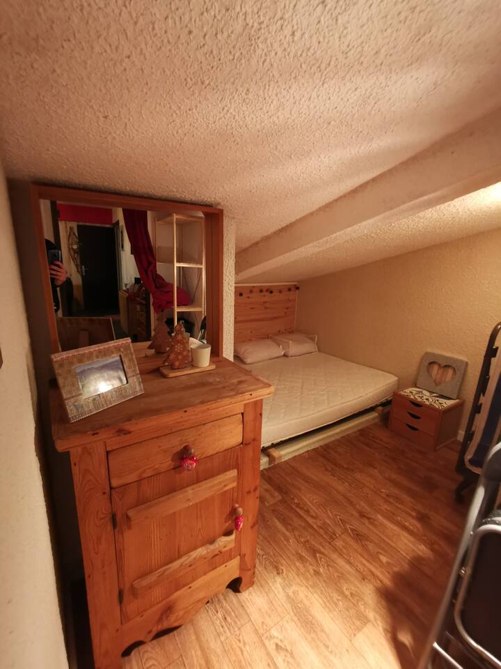 El pequeño espacio nocturno inclinado con su cama de 140 x 190 y una cama supletoria.