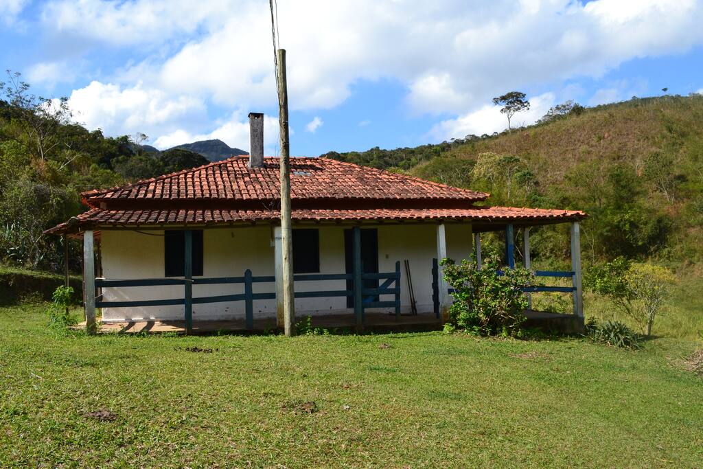 Extenso gramado e serra ao fundo, onde nascem as águas da fazenda.