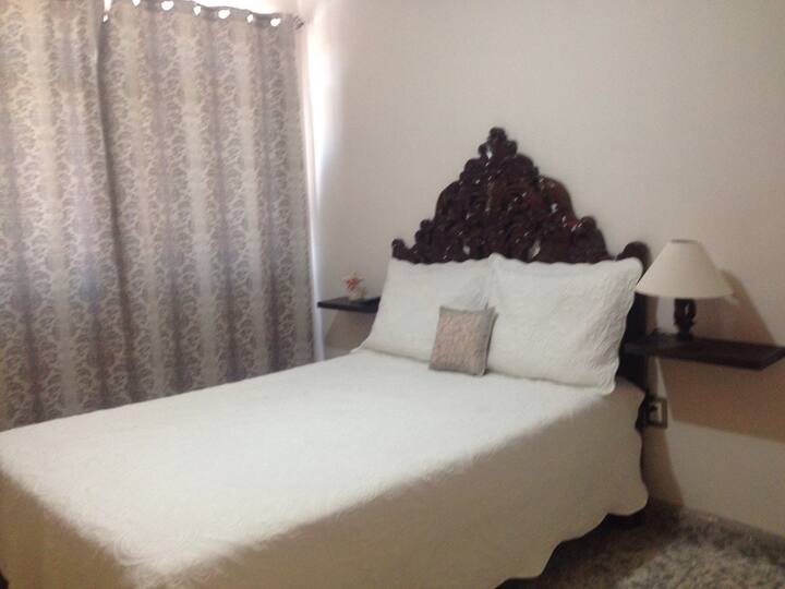 Quarto com cama de casal, tv, varanda na rua, ventilação muito iluminada e boa.