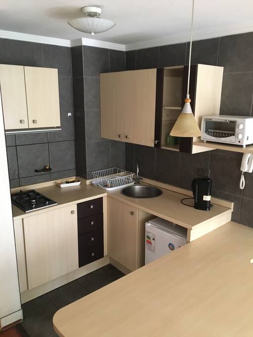 Cocina americana cuenta con frigobar, horno, cocina encimera, hervidor, servicios, ollas, etc.