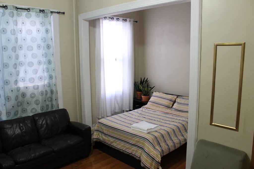 Great bedroom with natural light, comfortable bed and lounge sofa.