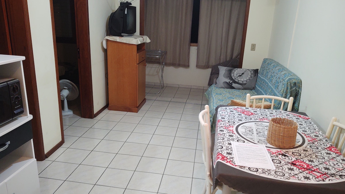 Salon et salle à manger, avec vue sur le balcon avec fenêtre et portes de la chambre et de la salle de bain