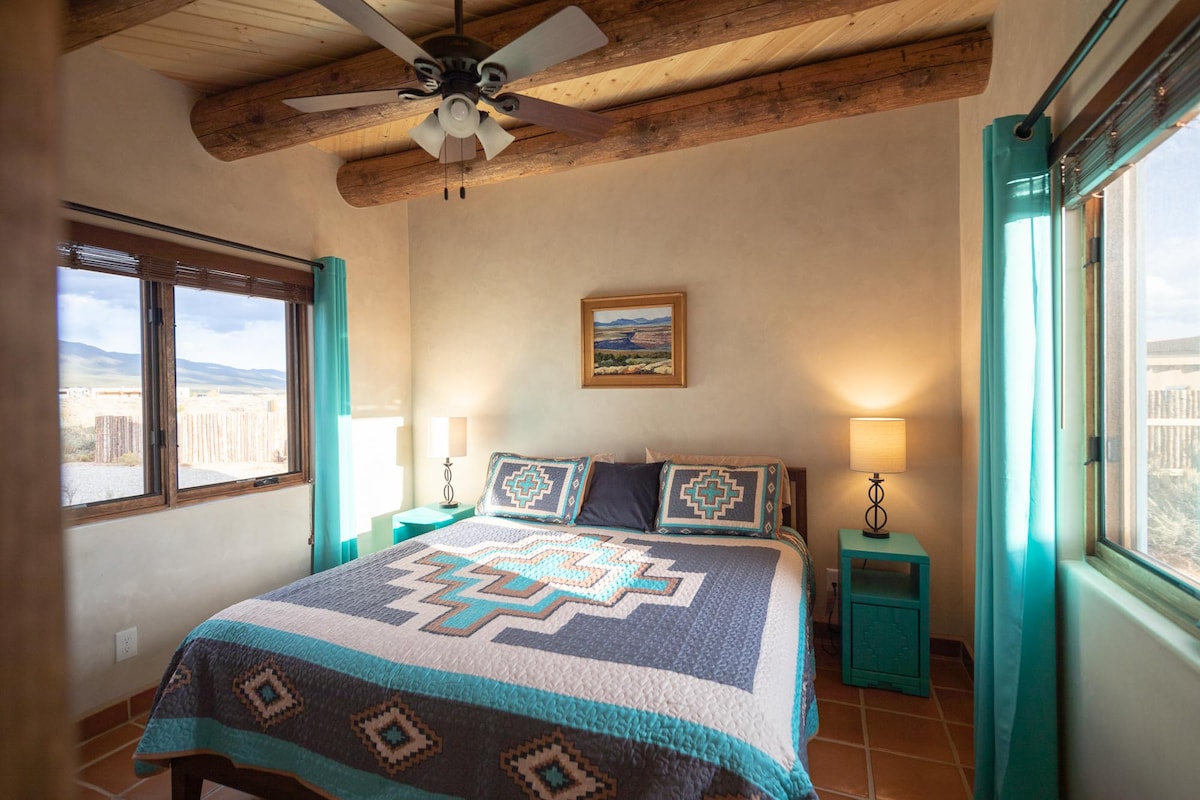 Slaapkamer met uitzicht op de bergen en kingsize bed. Plafondventilator voor jouw comfort.