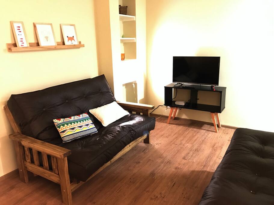 El living es super confortable y perfecto para relajarse tomando algo o ver cable o Netflix en la TV / The comfortable living room is perfect for relaxing having a beer or watching cable or Netflix on the TV. It also serves as second bedroom thanks to its double bed futon.