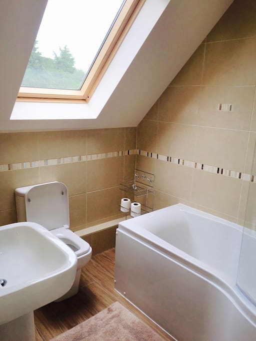 Bathroom with large bath and shower over.