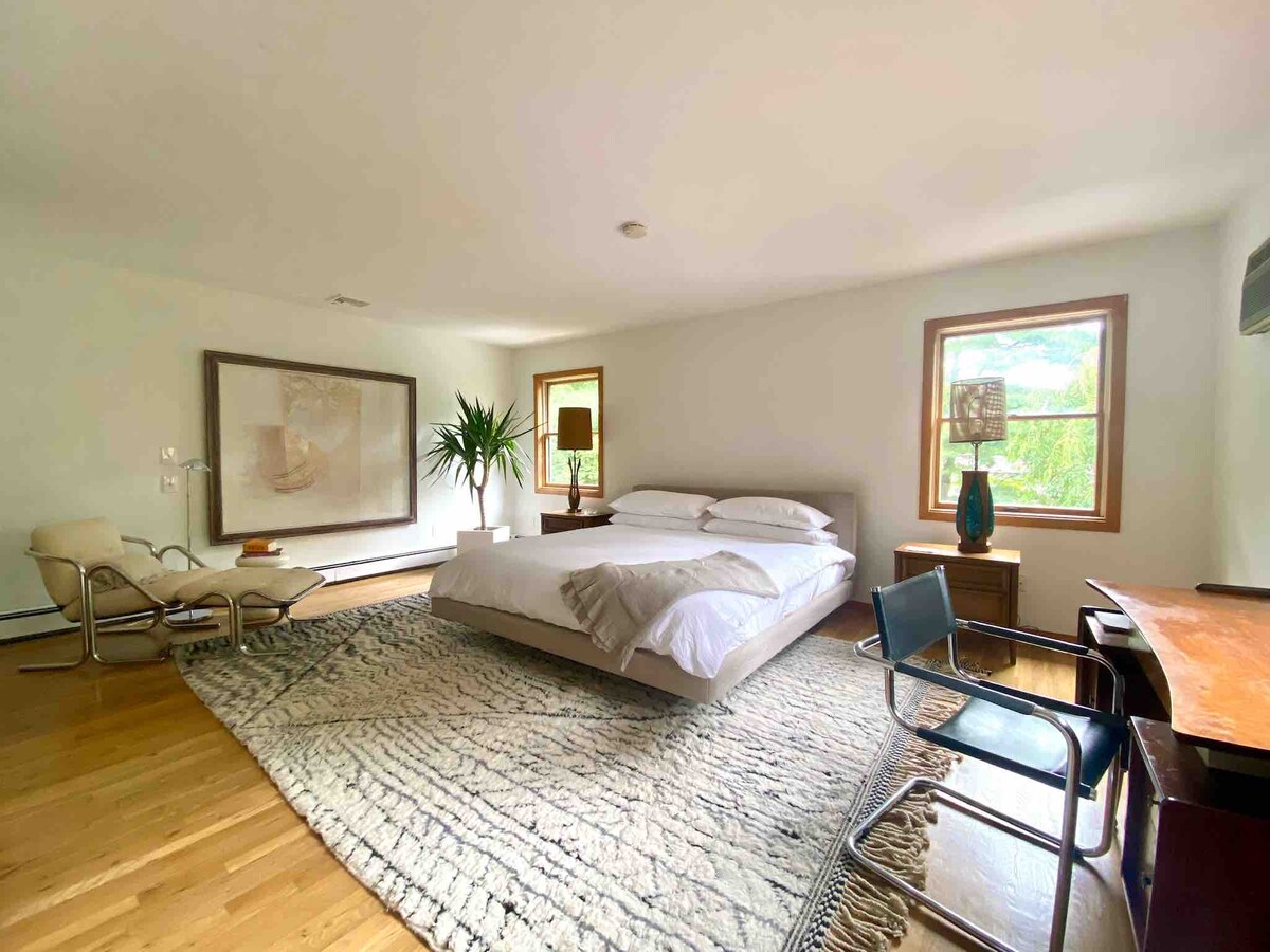 Chumba kikubwa cha kulala cha King na 65" TV, dawati la kufanya kazi mbele ya dirisha, kiti cha kupumzikia cha katikati ya karne, na bafu la kibinafsi lenye beseni la maji moto la watu 2.  Chumba hiki huwa na mwangaza mzuri asubuhi na kina thermostat tofauti ya kupasha joto. 