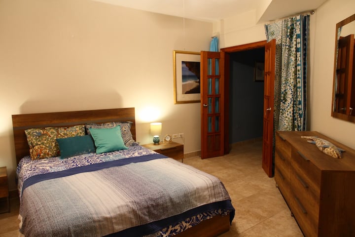 Dormitorio principal con un nuevo juego de muebles italianos y un nuevo colchón de bolsillo de primera calidad. La puerta se abre a la sala de estar para dejar entrar la hermosa vista al mar, junto con la brisa.