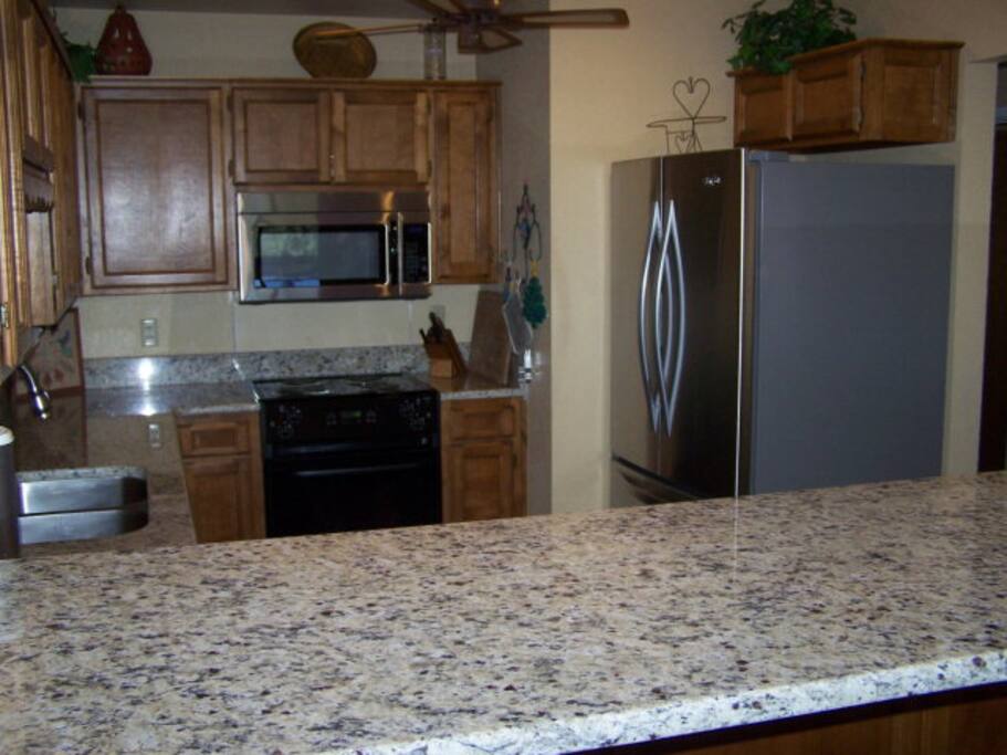 Updated and fully stocked kitchen with granite countertops and stainless steel appliances
