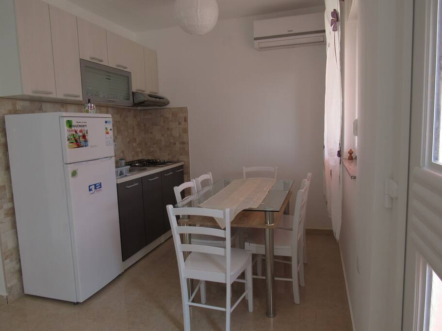 A little cute kitchen with a table for six persons.
