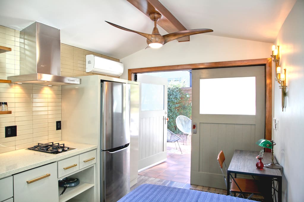 Full sized desk and Refrigerator, both doors open onto the patio creating a seemless indoor outdoor enviroment.