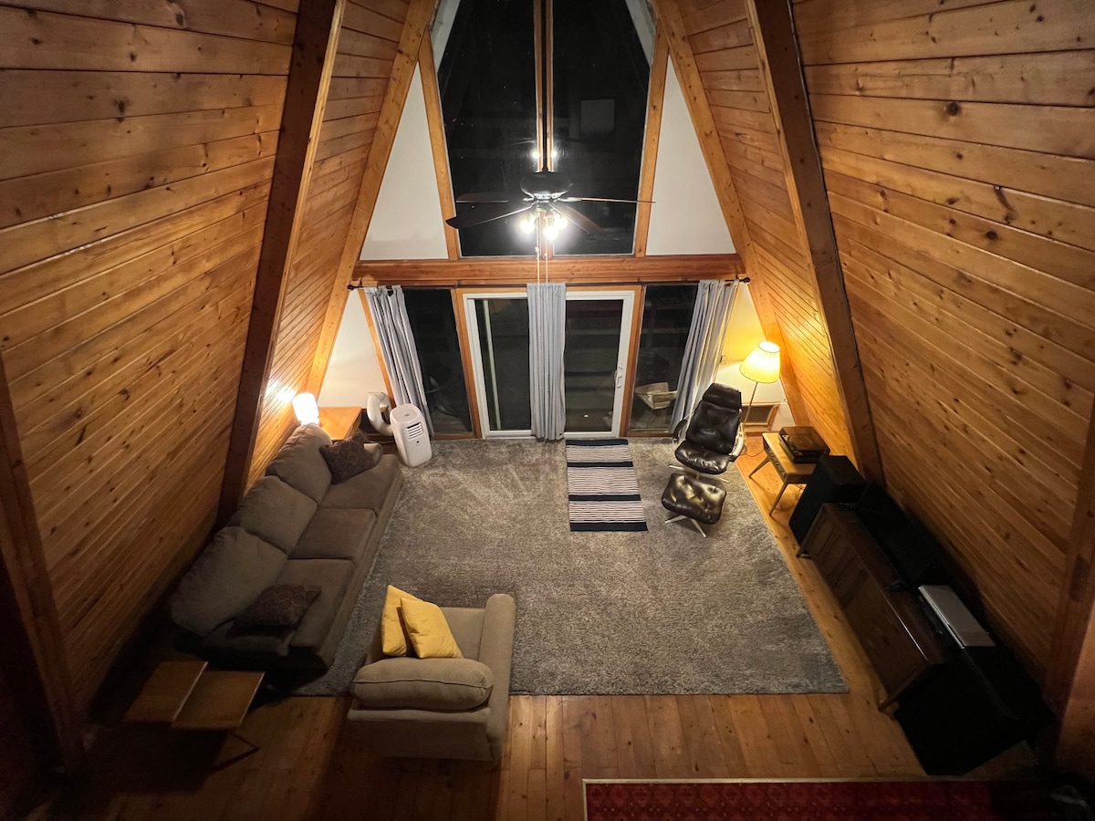 Cabaña de estilo alpino con vista a la sala de estar desde el loft.
