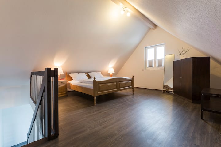 dhomë gjumi e rehatshme nën çati, dollap dhe pasqyrë