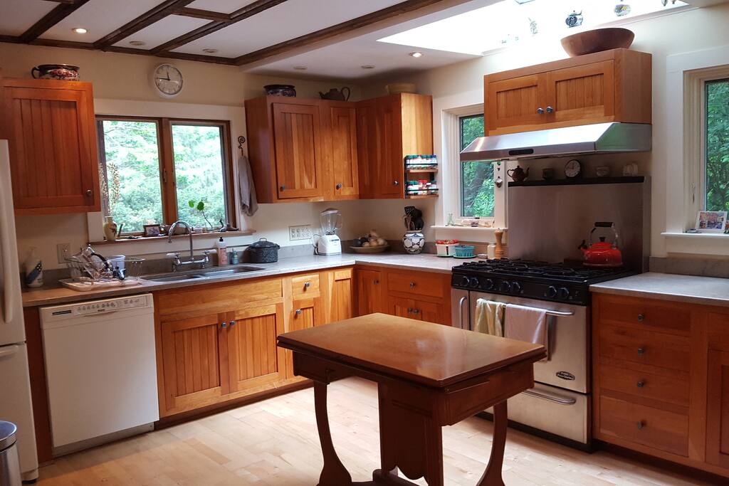 large renovated kitchen with 6 burner stove and stone countertops