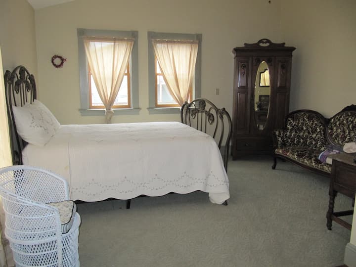 Dormitorio con cama tamaño queen y sala de estar