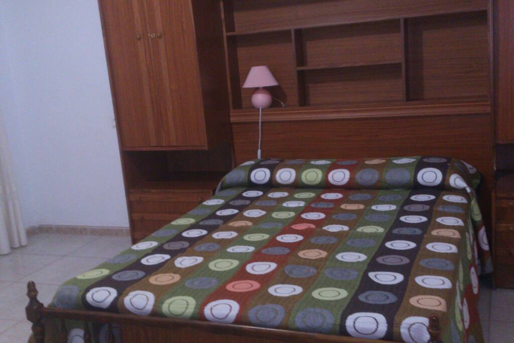 Cuarto con cama de matrimonio, y su armario.